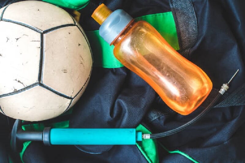 A football with a water bottle and a pump