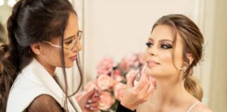 Makeup artist apply lipstick on brides lips
