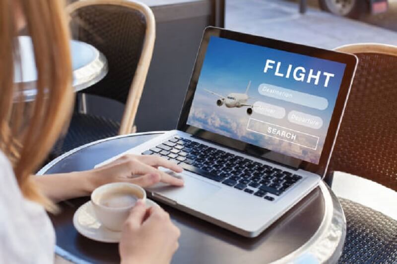 Woman booking a flight using a laptop