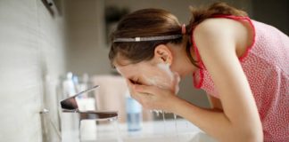 Girl washing her face with soap