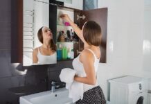 Woman putting something into the bathroom cabinet