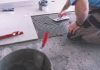 Man applying tiles on ground