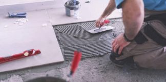 Man applying tiles on ground