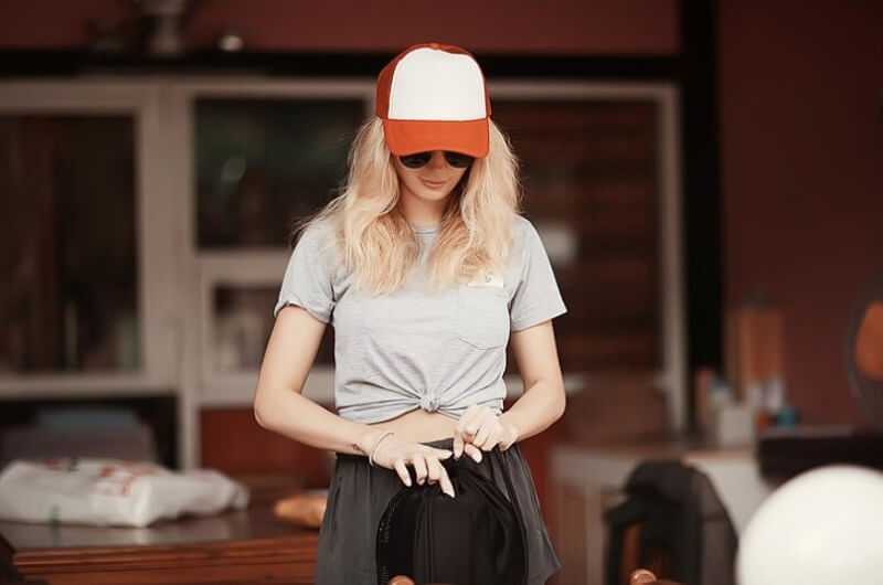 woman wearing a Bucket Hats and hand holding black bag