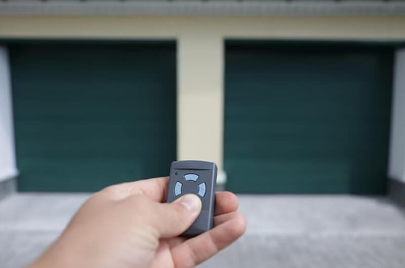 man hand holding garage door opener key