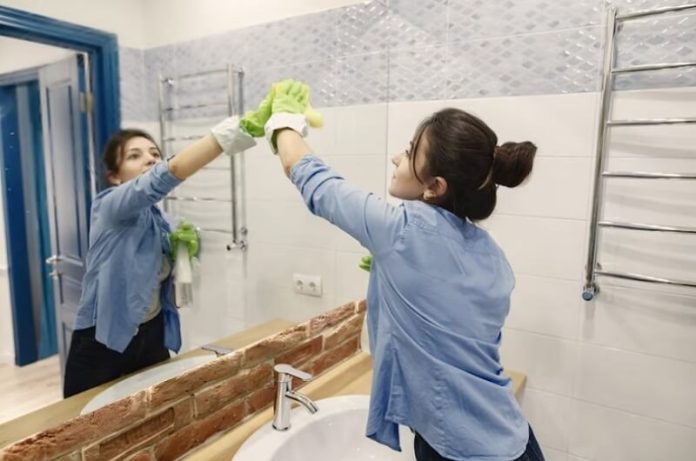 woman cleaning a mirror