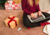 woman using a laptop and sitting near giftbox