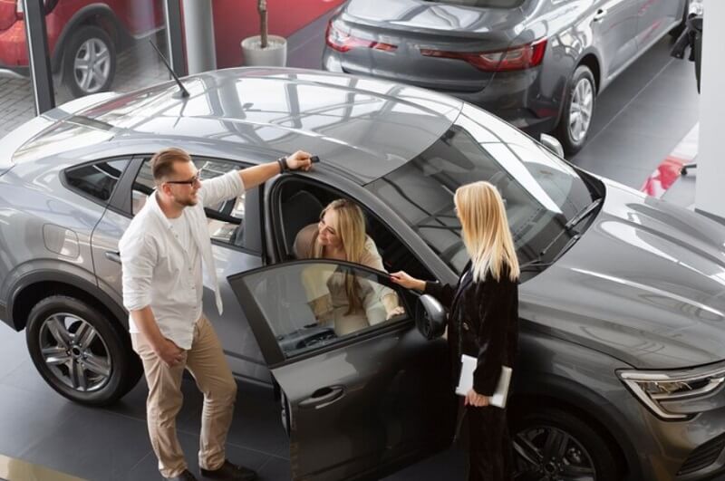 man and woman buying a used car